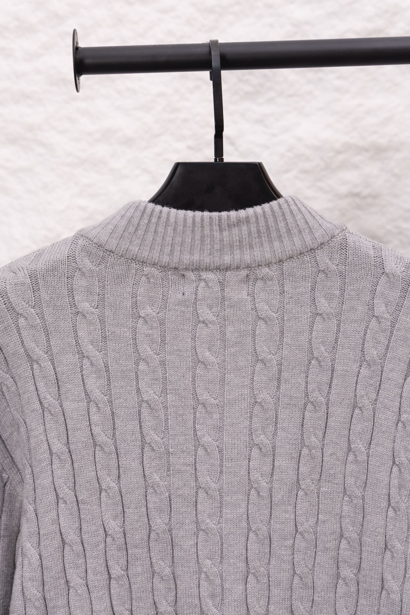 Light gray cable-knit sweater back with ribbed stand collar