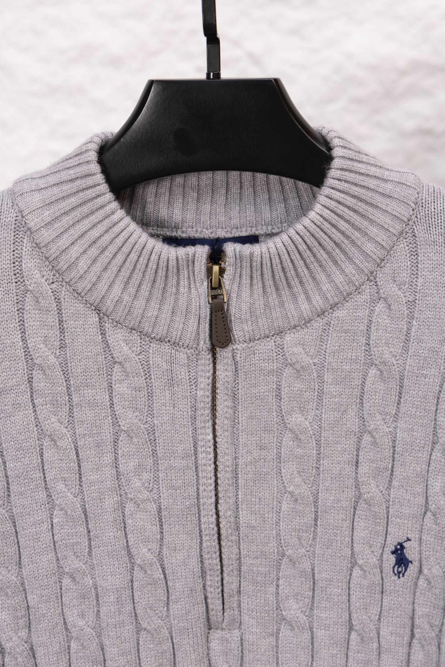 Light gray ribbed stand-collar sweater with gold zipper and polo logo