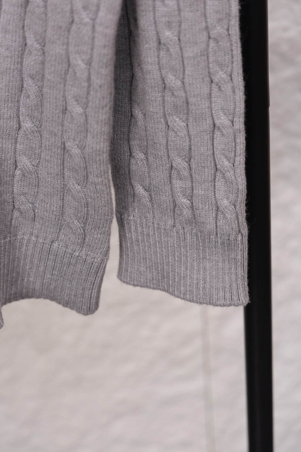 Light gray cable-knit sweater hem and cuffs with ribbed detailing