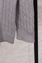 Light gray cable-knit sweater hem and cuffs with ribbed detailing
