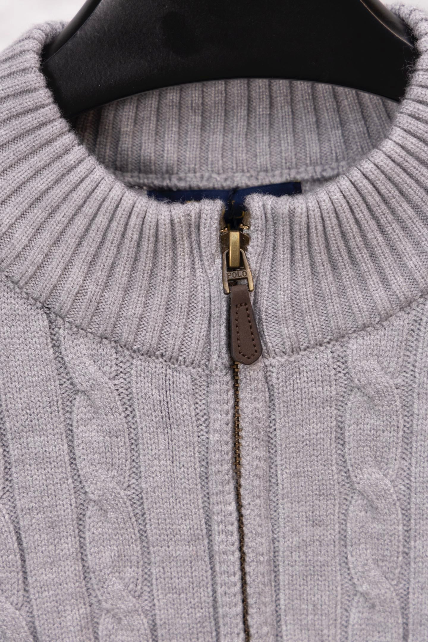 Light gray quarter-zip sweater with gold zipper and ribbed neckline