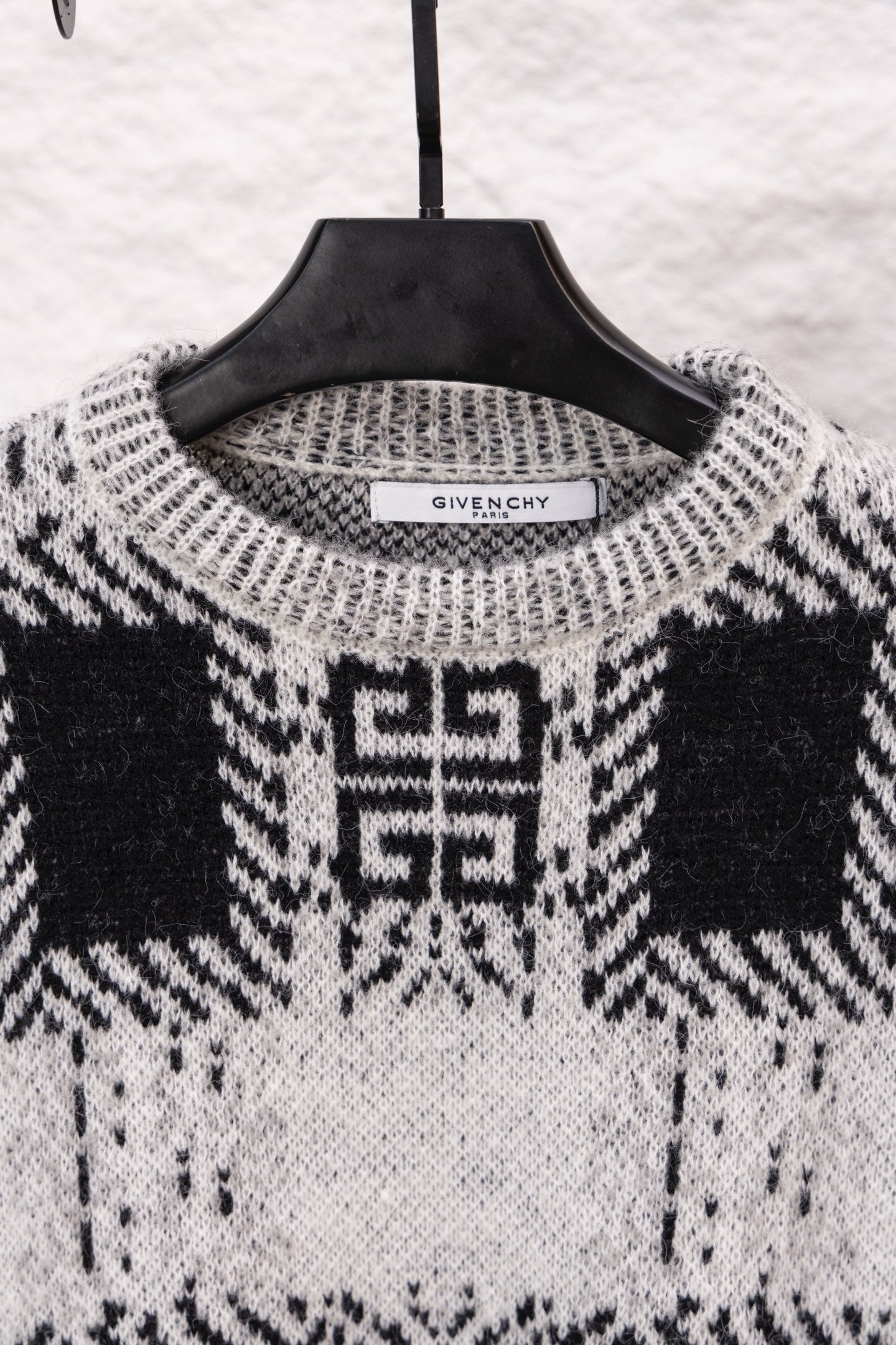 Givenchy knit sweater neckline in black and white with geometric pattern; brand label