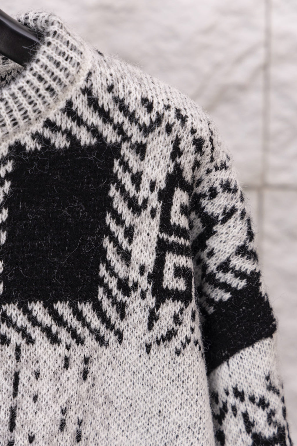 Givenchy knit sweater shoulder and sleeve close-up with black and white geometric motif