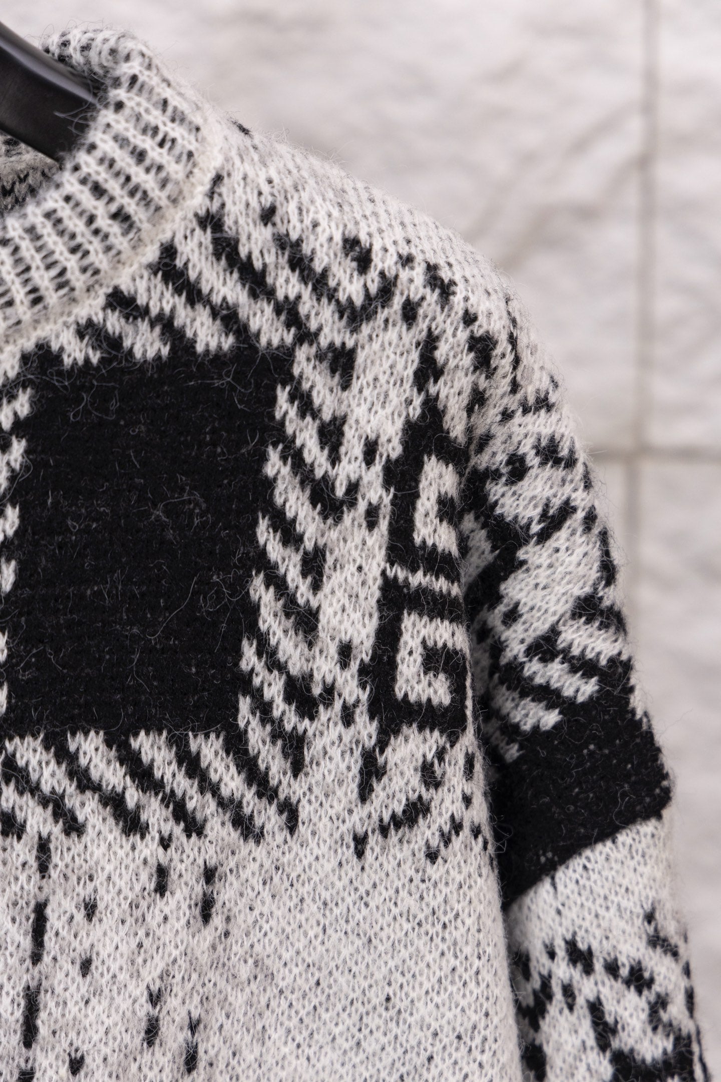 Givenchy knit sweater shoulder and sleeve close-up with black and white geometric motif