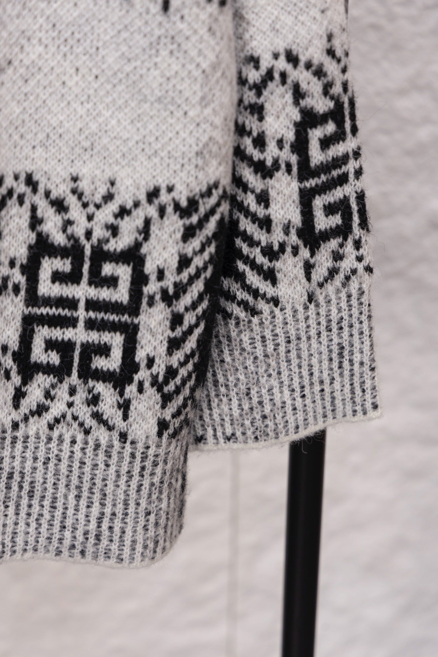 Givenchy knit sweater sleeve close-up in black and white geometric jacquard pattern