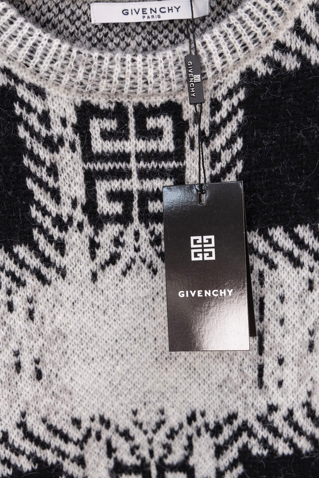 Givenchy knit sweater close-up with black and white geometric pattern and hanging tag