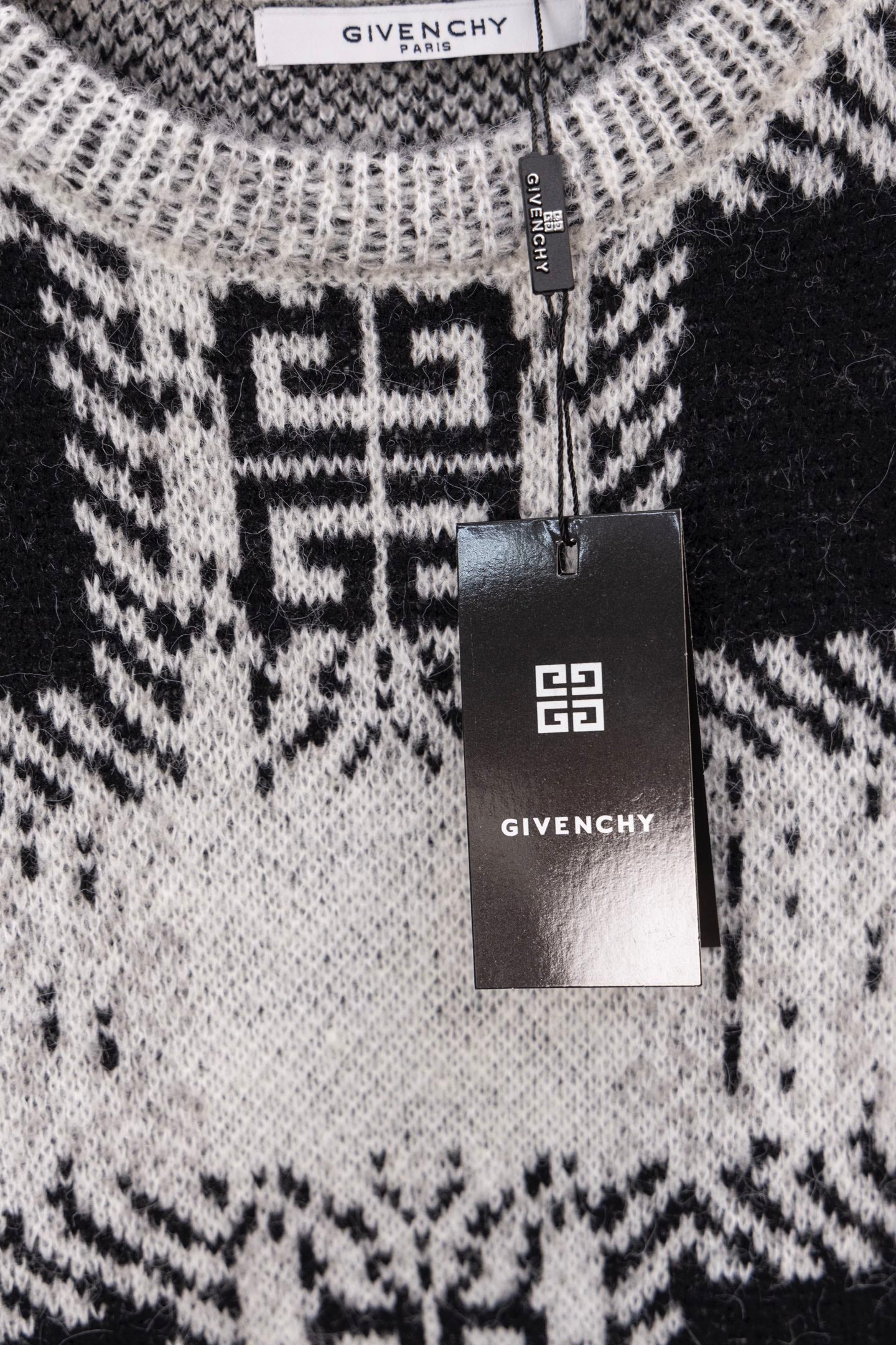 Givenchy knit sweater close-up with black and white geometric pattern and hanging tag