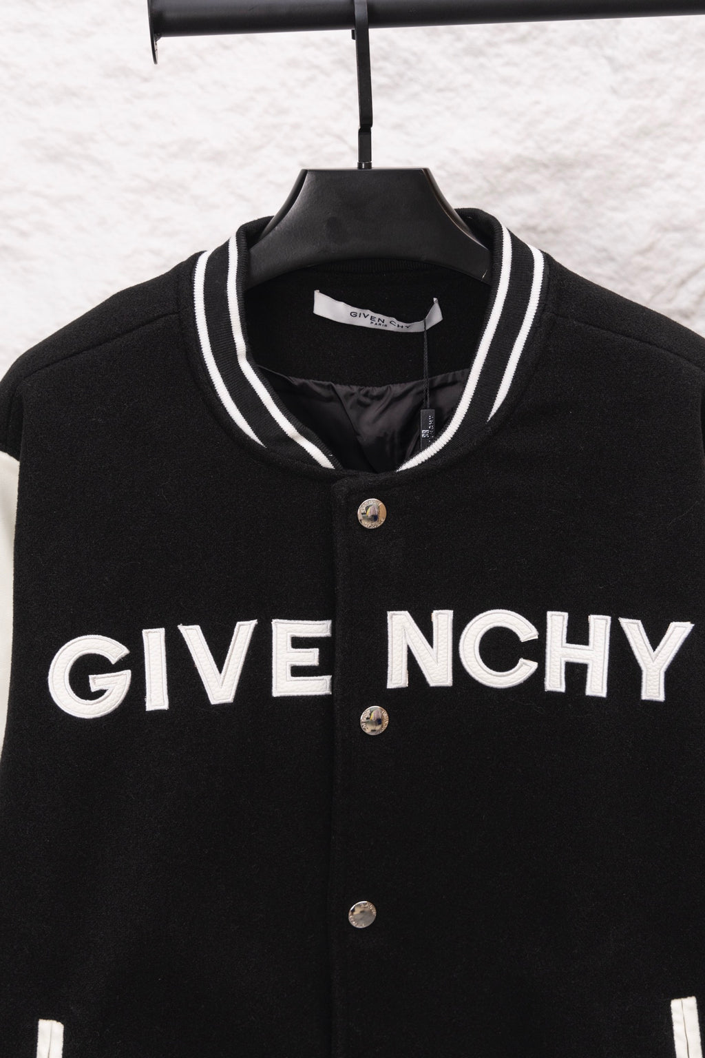 Givenchy black varsity jacket front close-up with GIVE NCHY print and snap placket