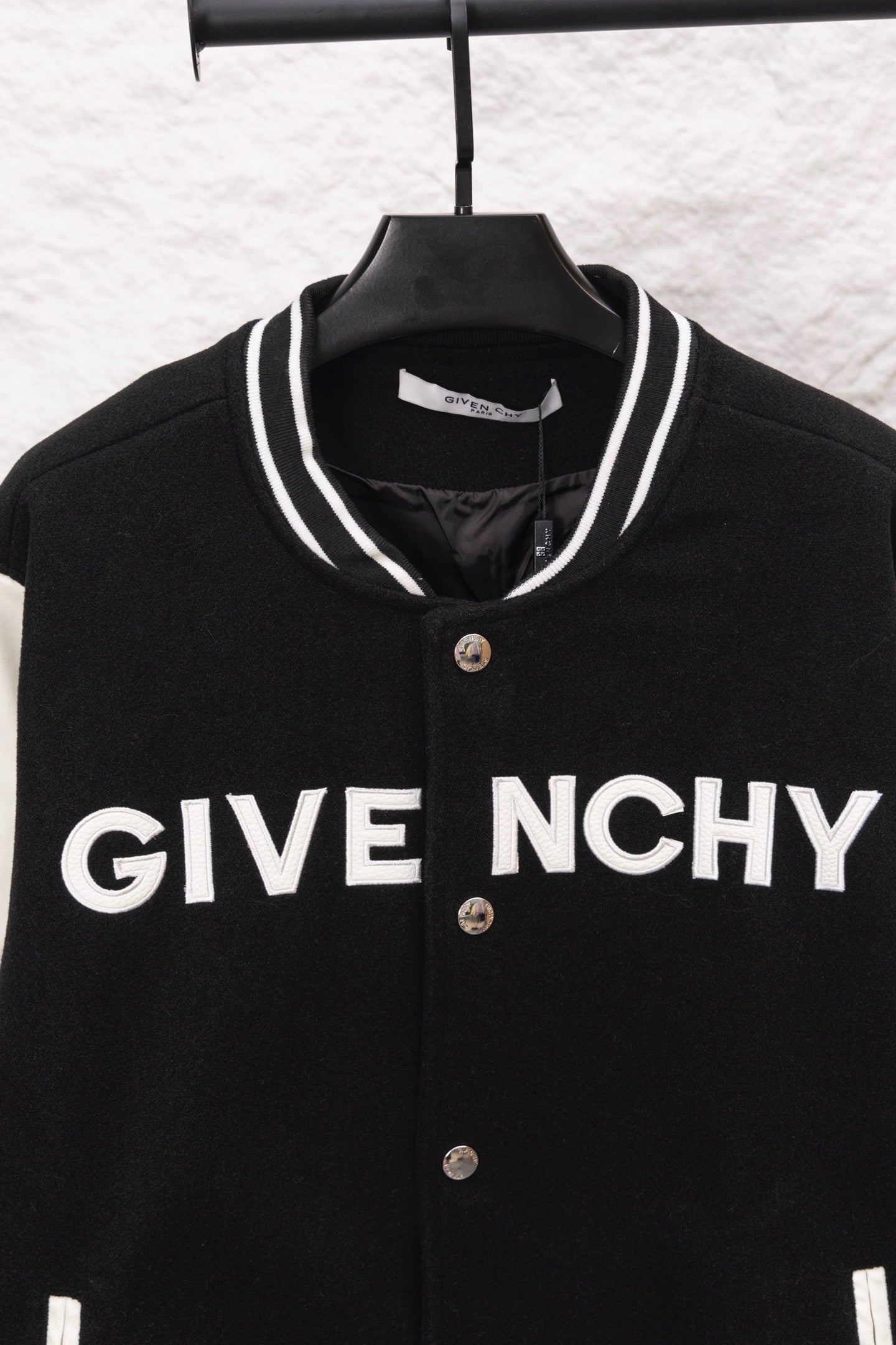 Givenchy black varsity jacket front close-up with GIVE NCHY print and snap placket