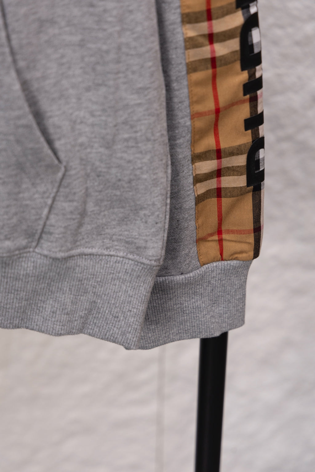 Grey sweatshirt sleeve cuff and hem with vertical check plaid panel