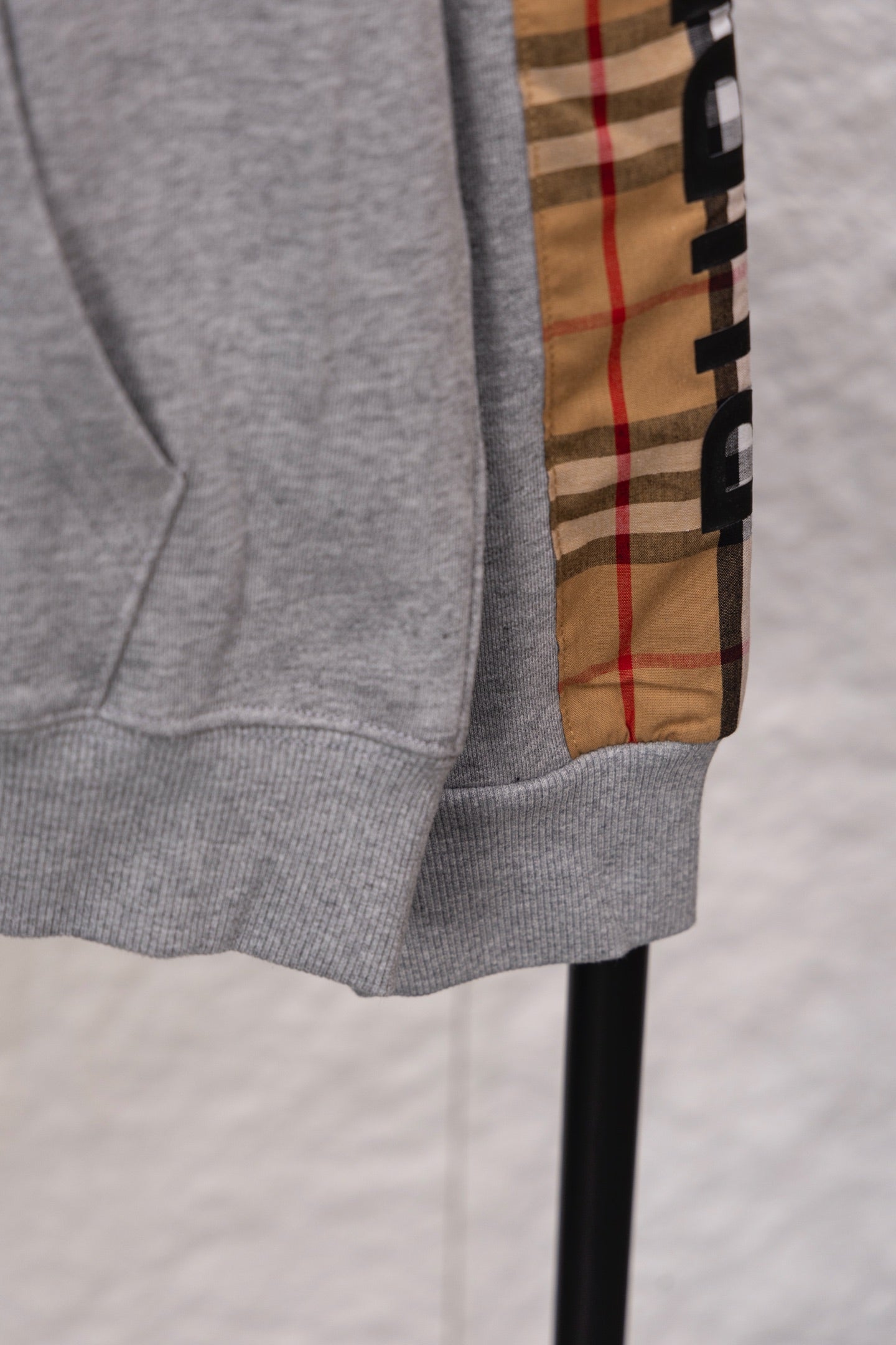 Grey sweatshirt sleeve cuff and hem with vertical check plaid panel