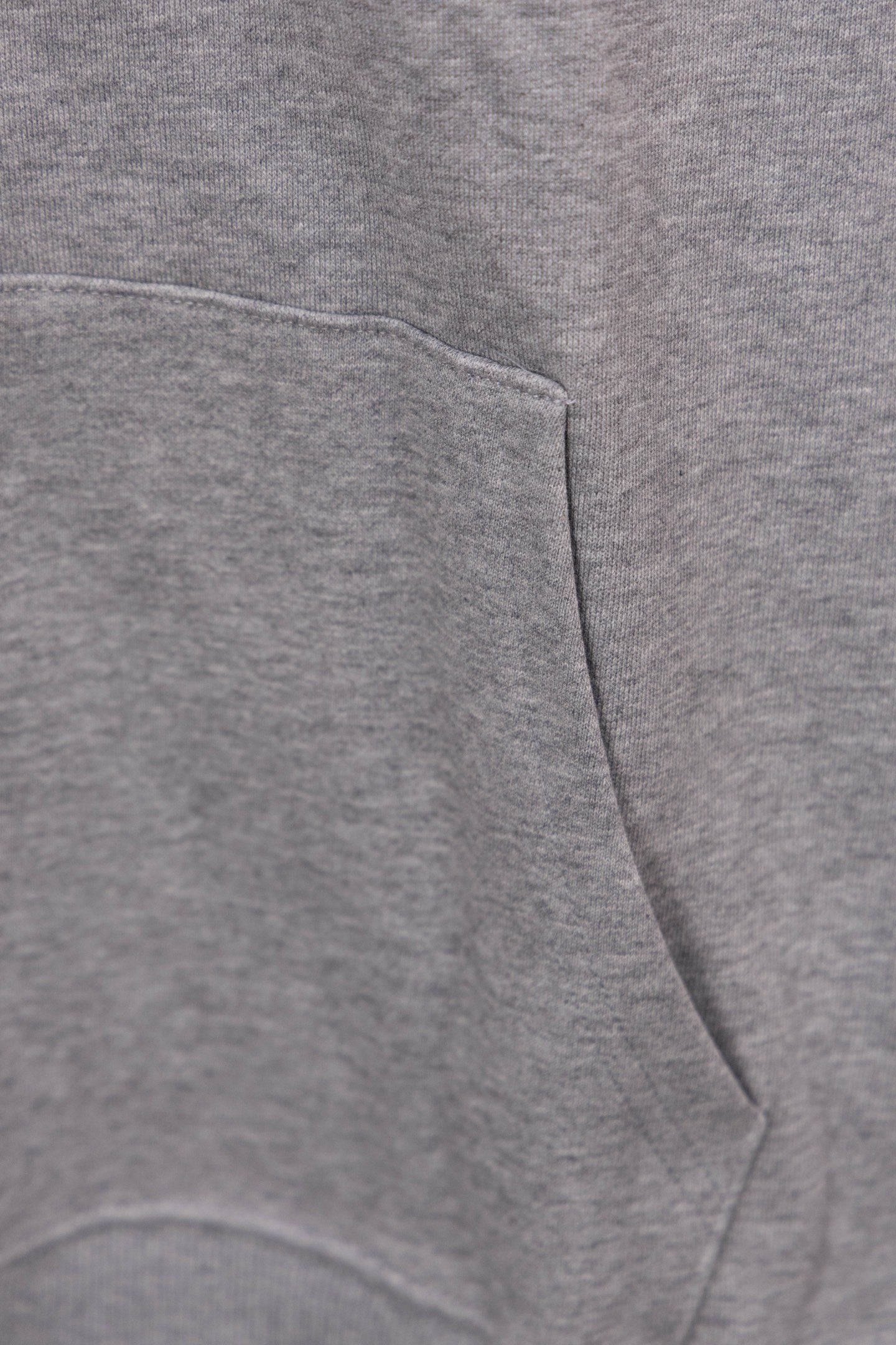 Heather gray hoodie front pocket and drawstring hem seam detail