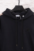 Black hoodie front close-up with hood drawstrings and small embroidered logo