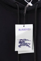 Black hoodie close-up with Burberry logo tag at the hood drawstring area