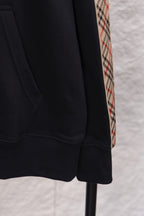 Black hoodie lower front detail with side seam stitching and ribbed hem