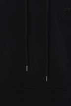 Black hoodie hood drawstrings close-up with metal tips and subtle logo
