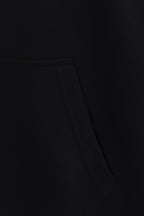 Black hoodie fabric close-up with waist seam and stitched panel detail
