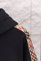 Black hoodie sleeve cuff with check-pattern trim along the side edge