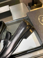 Prada black leather loafer close side view with block heel and rounded toe