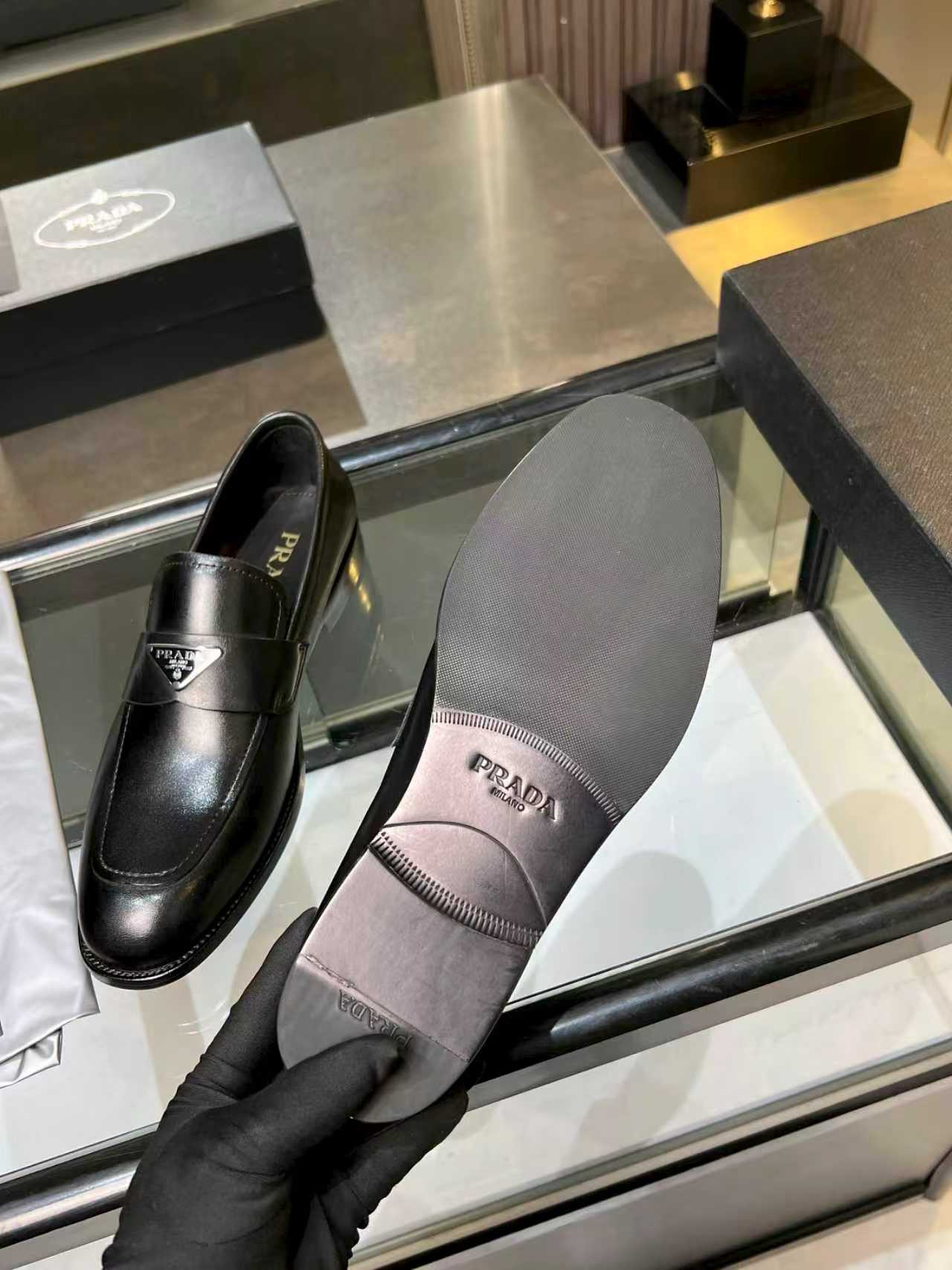 Prada black leather loafers with interior label visible, unisex slip-on