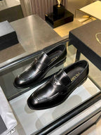 Prada black leather loafers, front pair view with stitched apron and crest