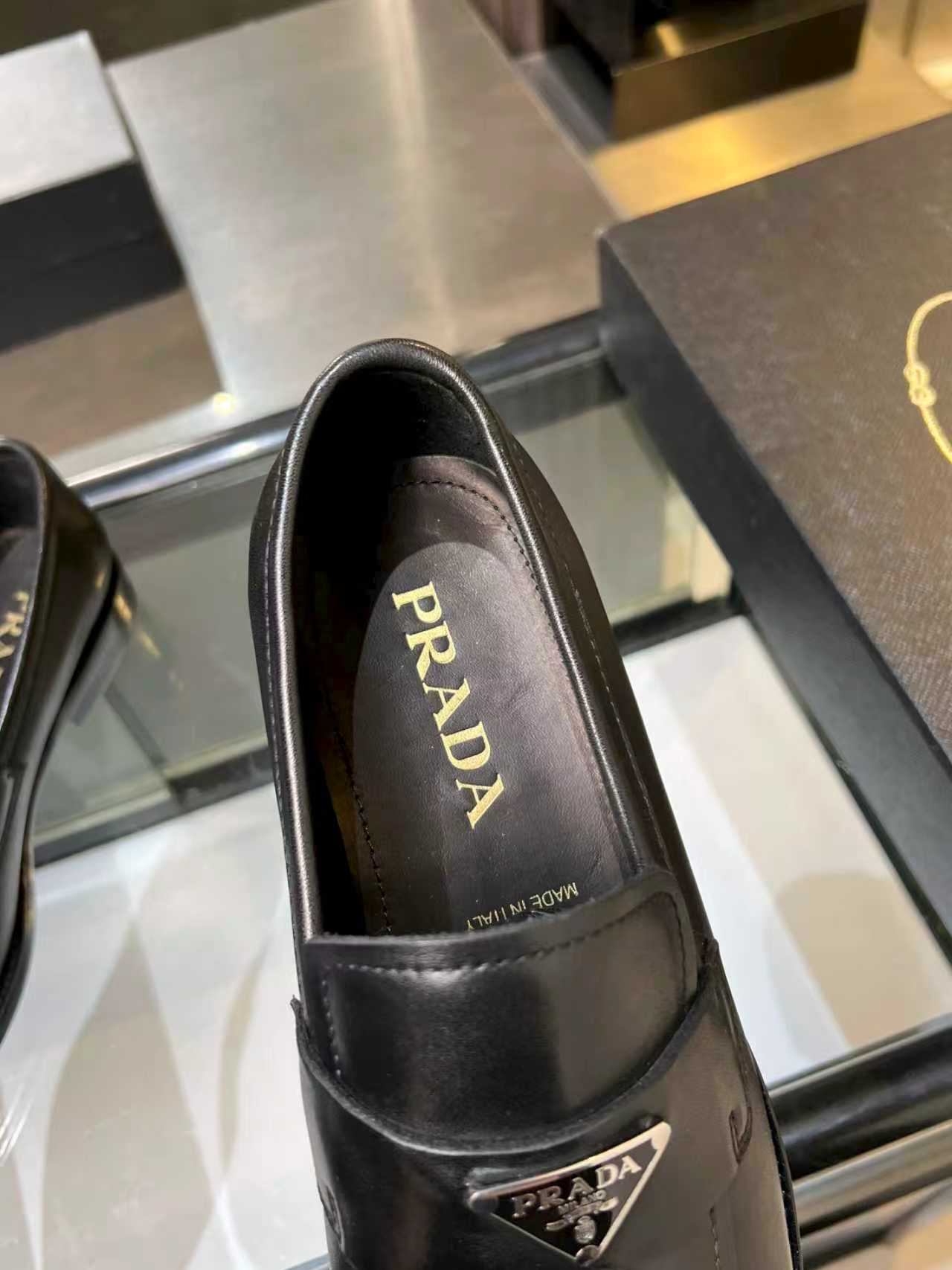 Prada black leather loafer showing interior lining and PRADA lettering