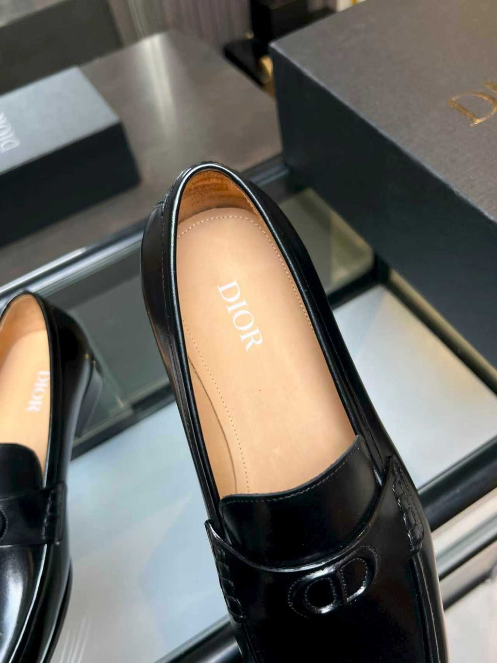 Black leather loafer showing tan insole with Dior text and front logo