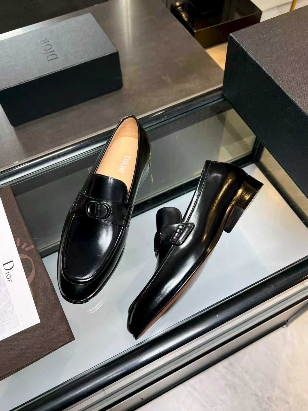 Black leather loafers with Dior monogram buckle, two-shoe display