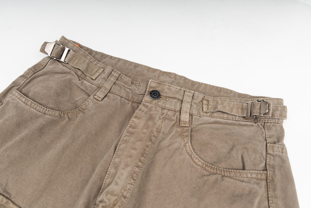 Tan cargo pants waistband close-up with button closure and front pockets