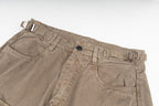 Tan cargo pants waistband close-up with button closure and front pockets