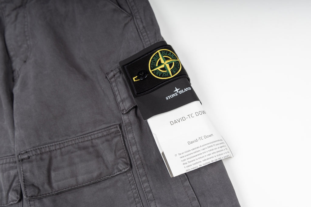 Stone Island cargo pants care label and patch on dark gray fabric