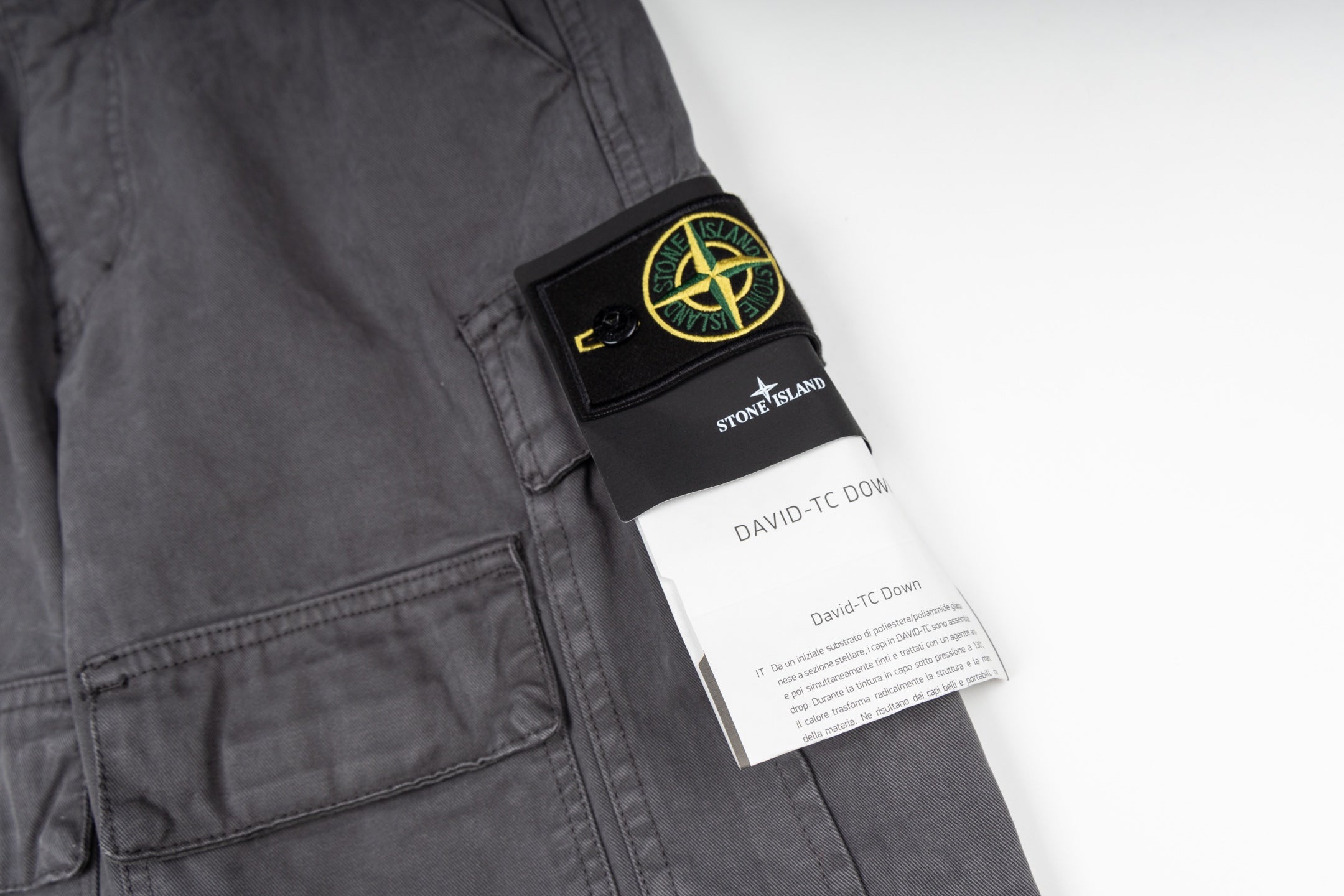Stone Island cargo pants care label and patch on dark gray fabric