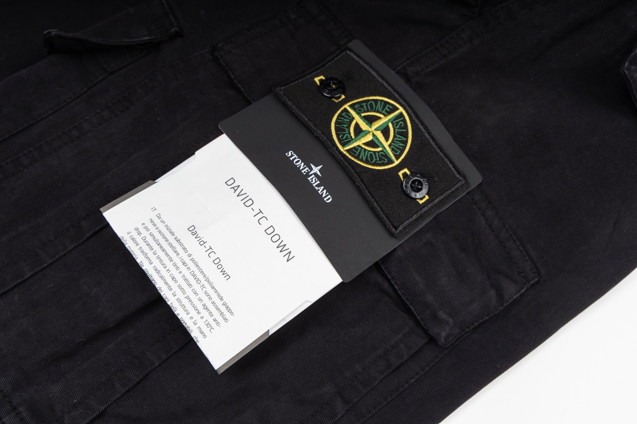 Black cargo trousers with Stone Island hang tag and care labels