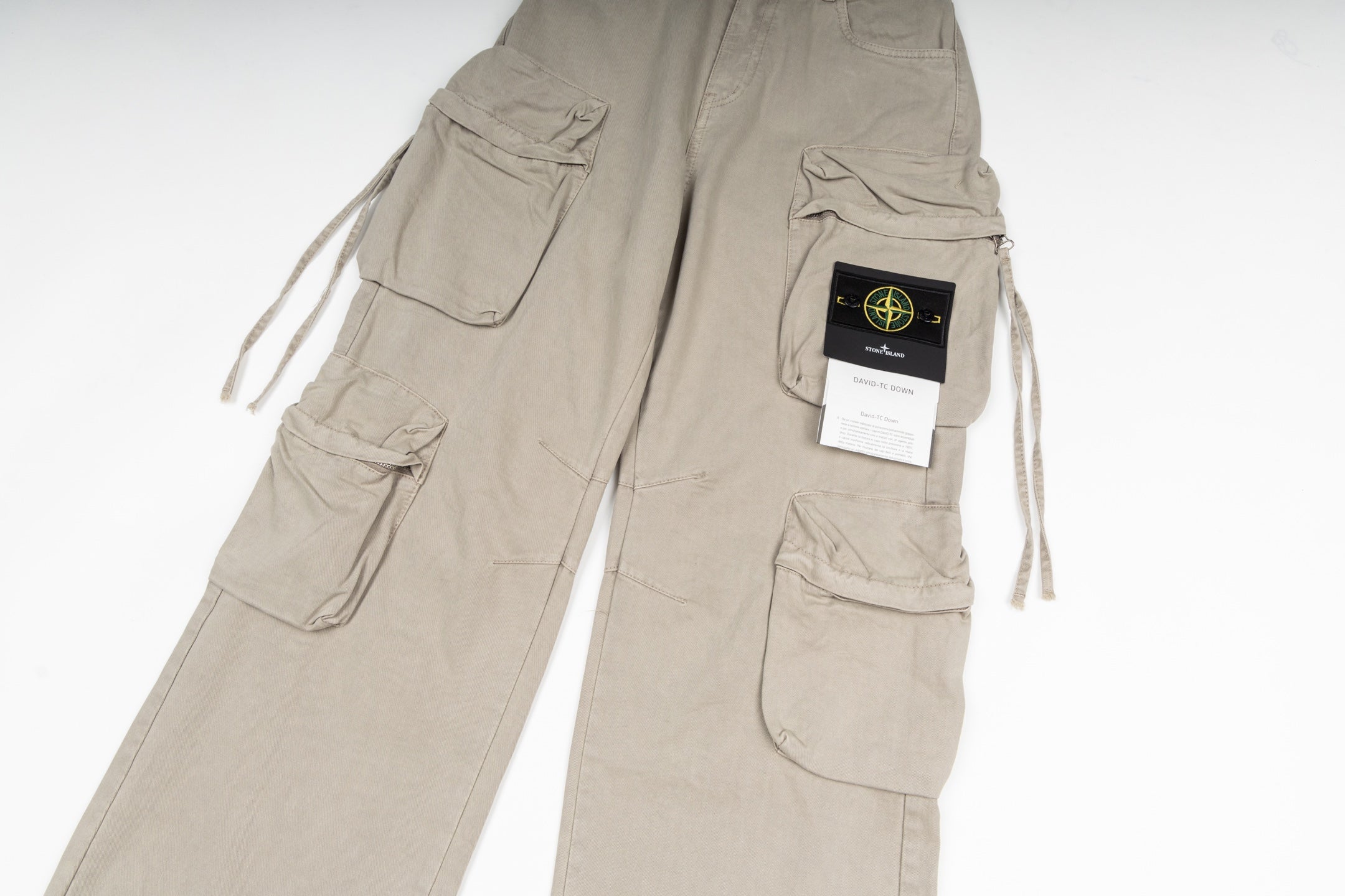 Stone Island cargo pants in sand, close-up of cargo pockets and label