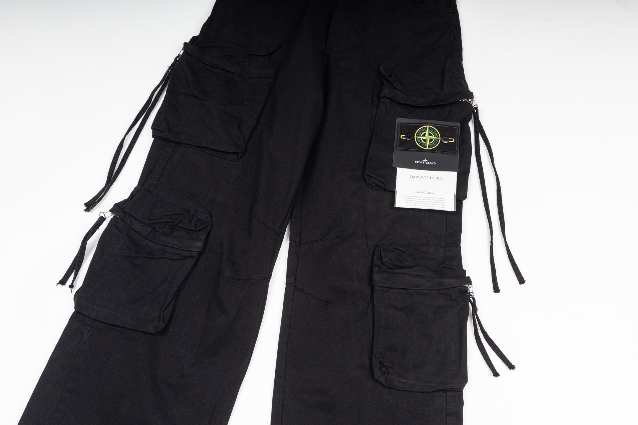 Stone Island cargo pants in black, close-up of cargo pockets and drawstring ties