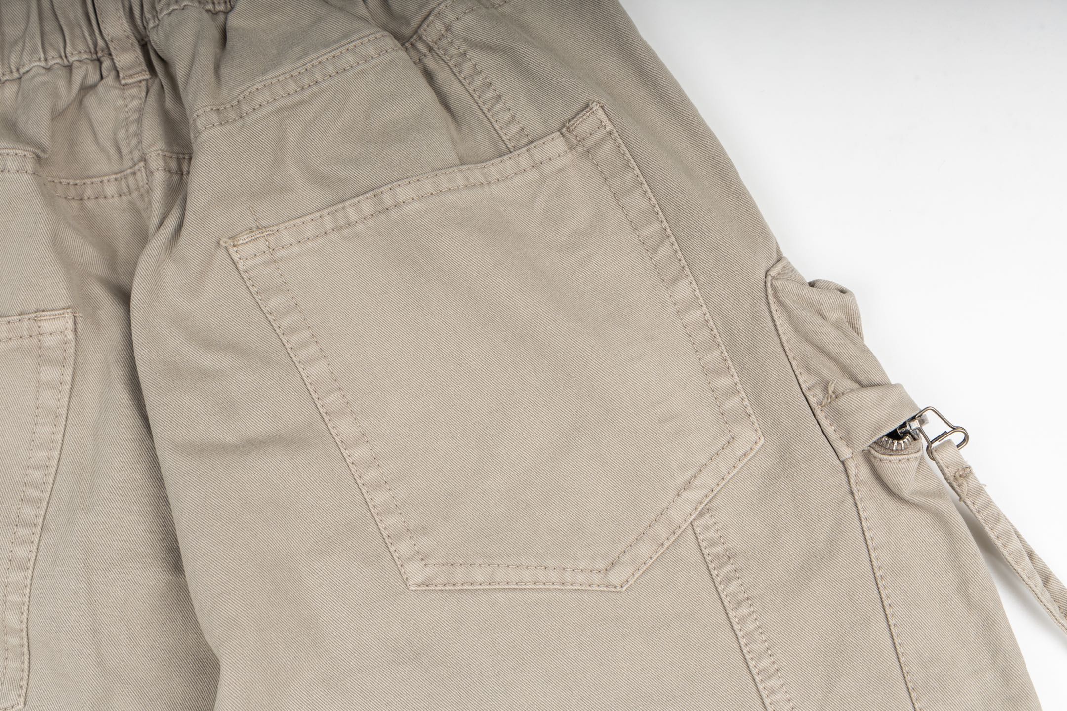 Stone Island cargo pants in sand, close-up of flap cargo pocket detail