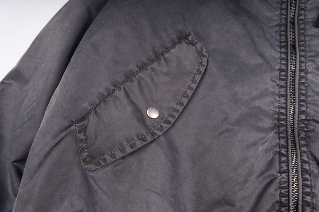 Dark gray bomber jacket with snap chest pocket and zipper track detail