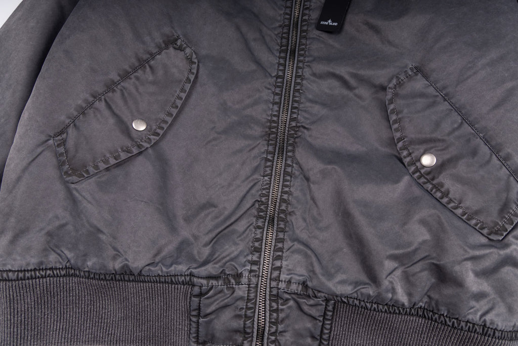 Dark gray bomber jacket with two snap-flap chest pockets and central zipper