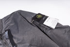 Dark gray bomber jacket with inner label and black hang tag over shoulder