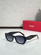 Prada sunglasses with black frame and dark blue-tinted lenses, side logo accents.