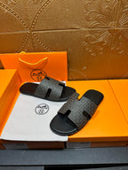 Hermes slide sandals top view, gray monogram-pattern straps on black rubber base