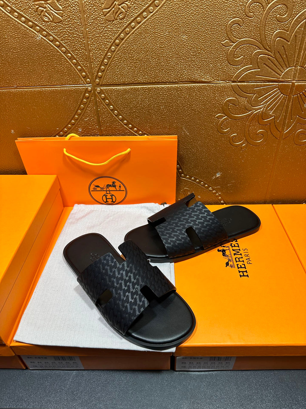 Hermes slide sandals with dark gray textured strap and black rubber footbed
