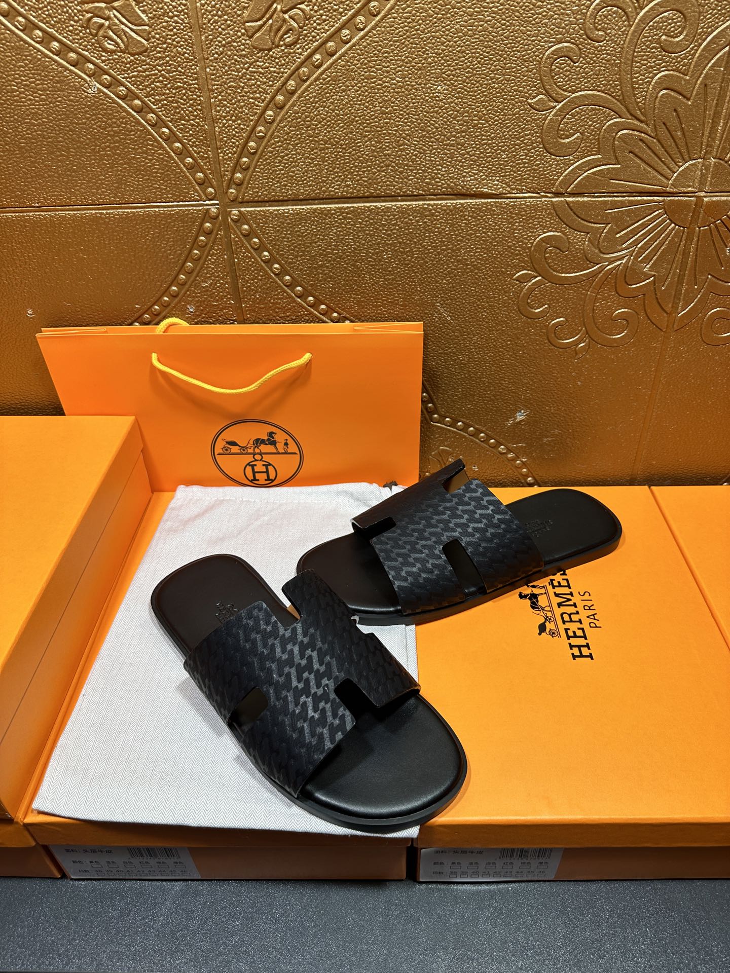 Hermes slide sandals with dark gray textured strap and black rubber footbed