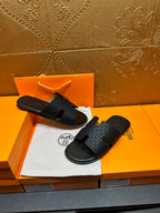 Hermes slide sandals with dark gray textured upper and black footbed