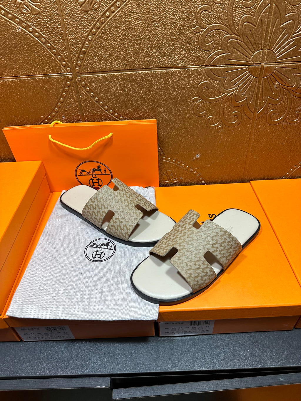 Hermes slide sandals shown with taupe patterned straps and white footbed