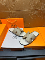 Hermes slide sandals shown with taupe patterned straps and white footbed