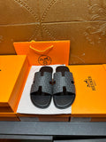 Hermes slide sandals with charcoal patterned straps and black rubber footbeds