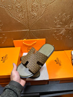 Hermes slide sandals with dark patterned slide straps and light gray footbeds