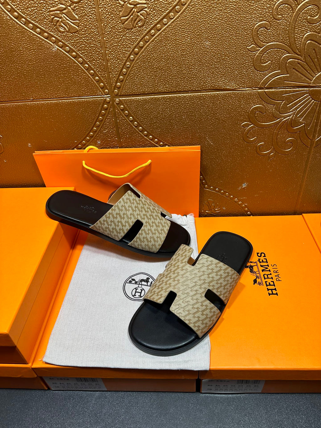 Beige and black slide sandals with patterned upper and black sole