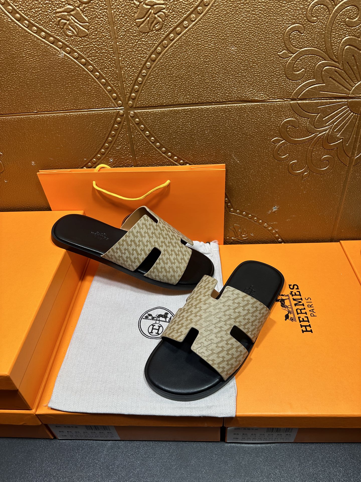 Beige and black slide sandals with patterned upper and black sole